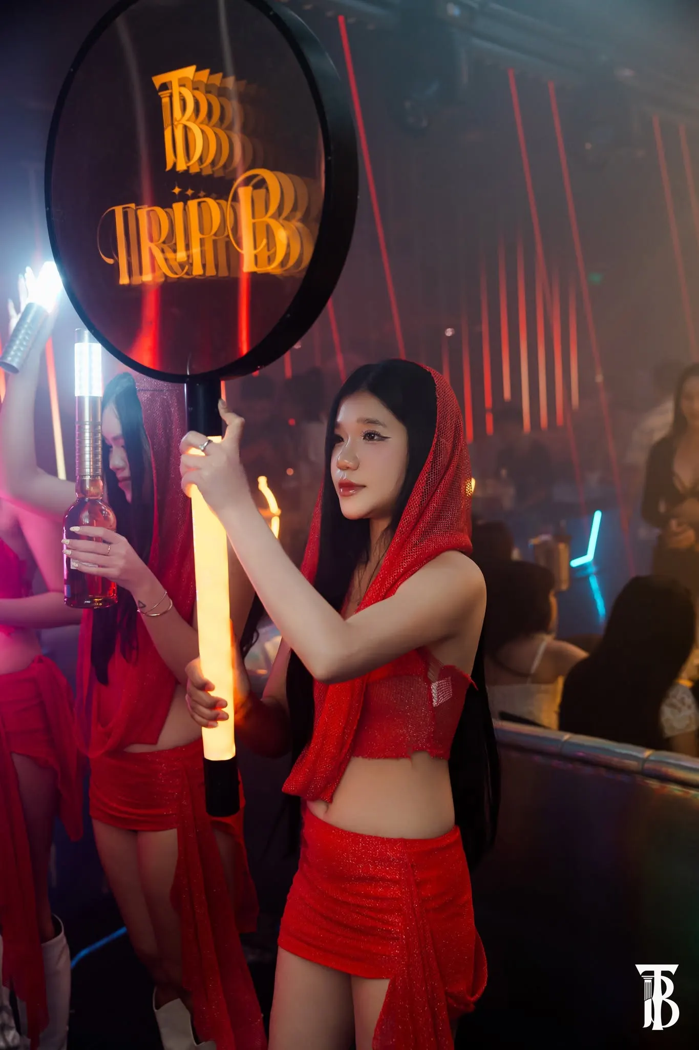 Khách cầm quạt in monogram TRIP B giữa sàn nhảy tại Trip B Club Bình Dương